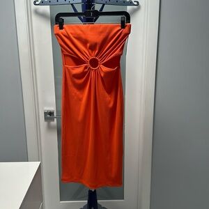 Vibrant Orange strapless dress with opening in the stomach area.